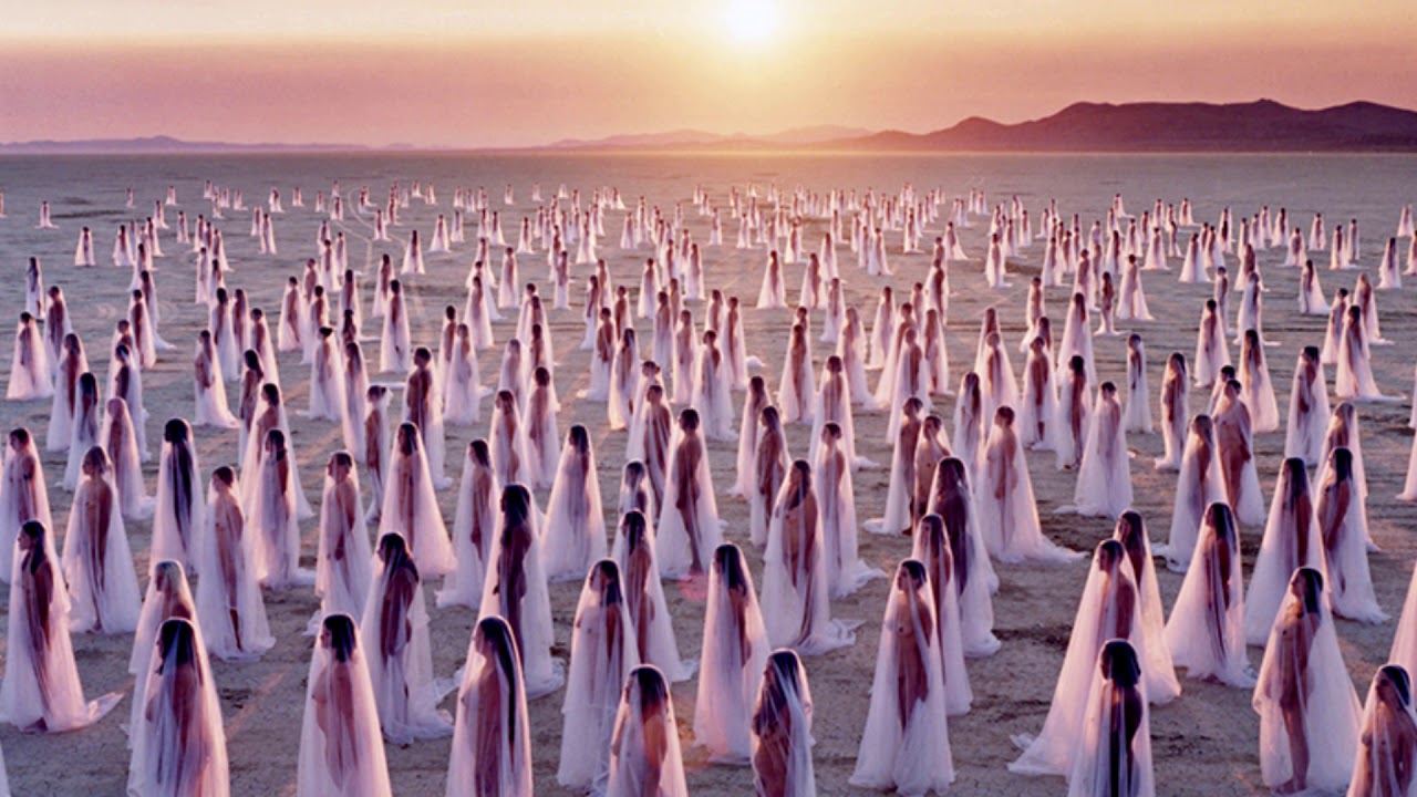 opera d'arte fatta da 500 persone nude Persone nude in piedi coperte da un velo trasparente, nel deserto