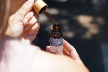 Olio CBD accanto a una pianta di canapa in un ambiente naturale