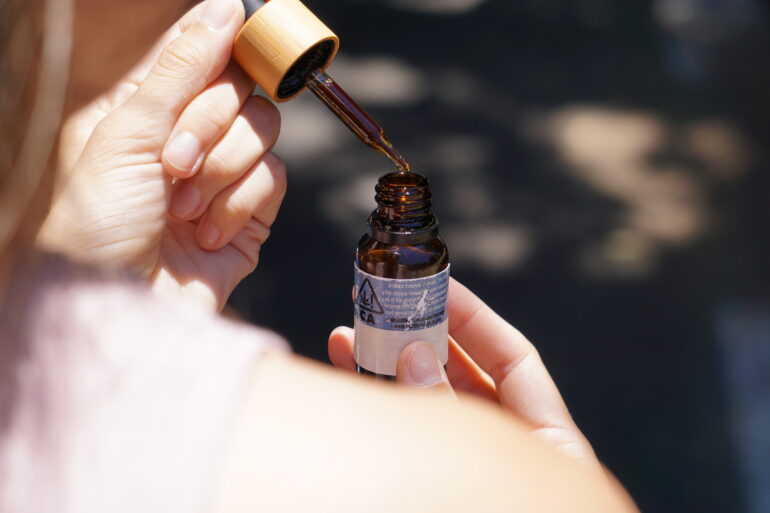 Olio CBD accanto a una pianta di canapa in un ambiente naturale
