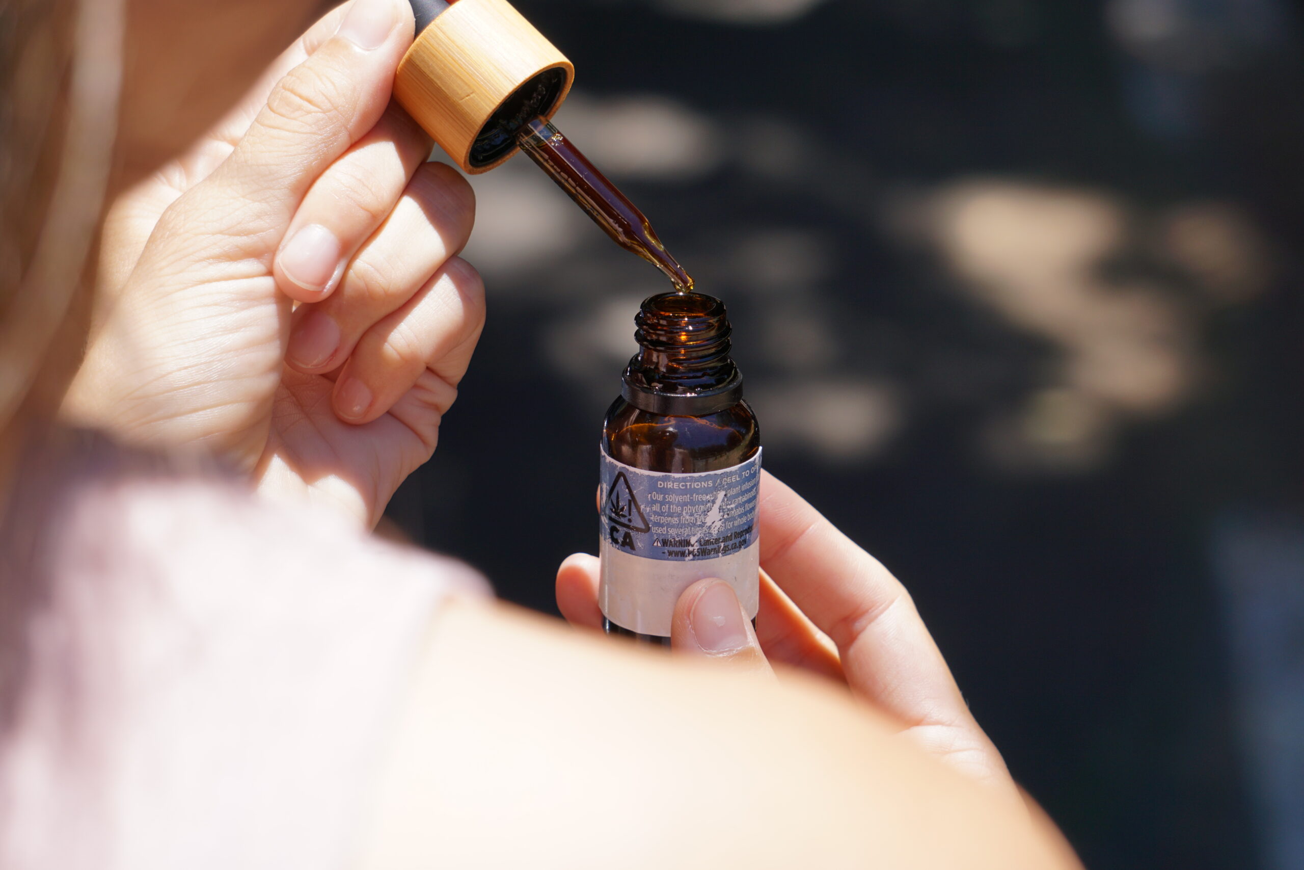 Olio CBD accanto a una pianta di canapa in un ambiente naturale